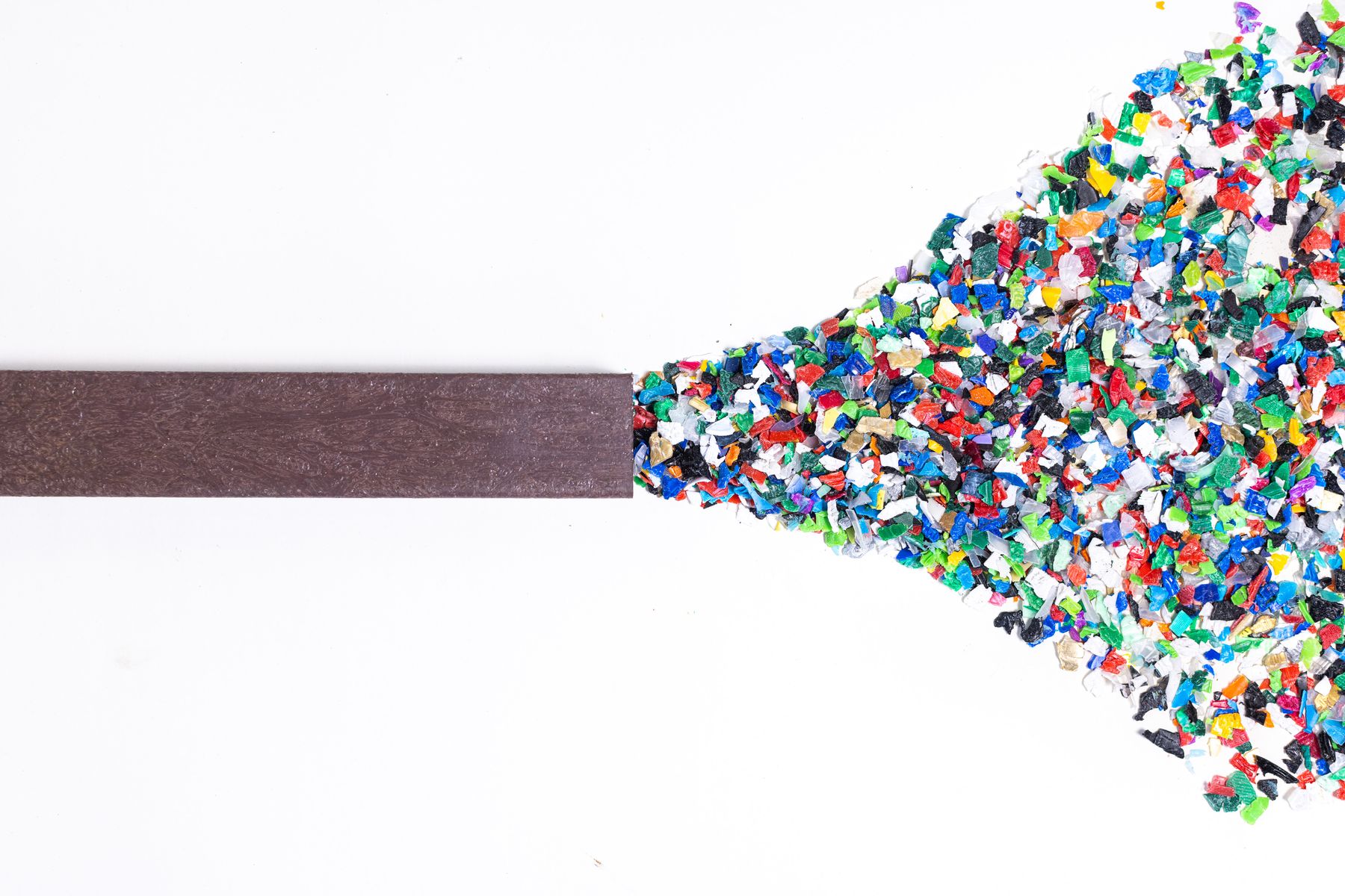 Brown Everwood plank transforming into shredded recycled plastic flakes