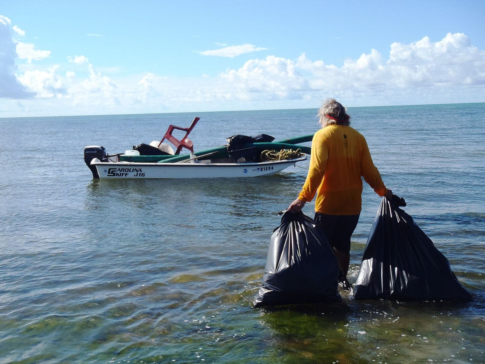 Volunteer hauling trash bags during a Florida Keys National Marine Sanctuary coastal cleanup